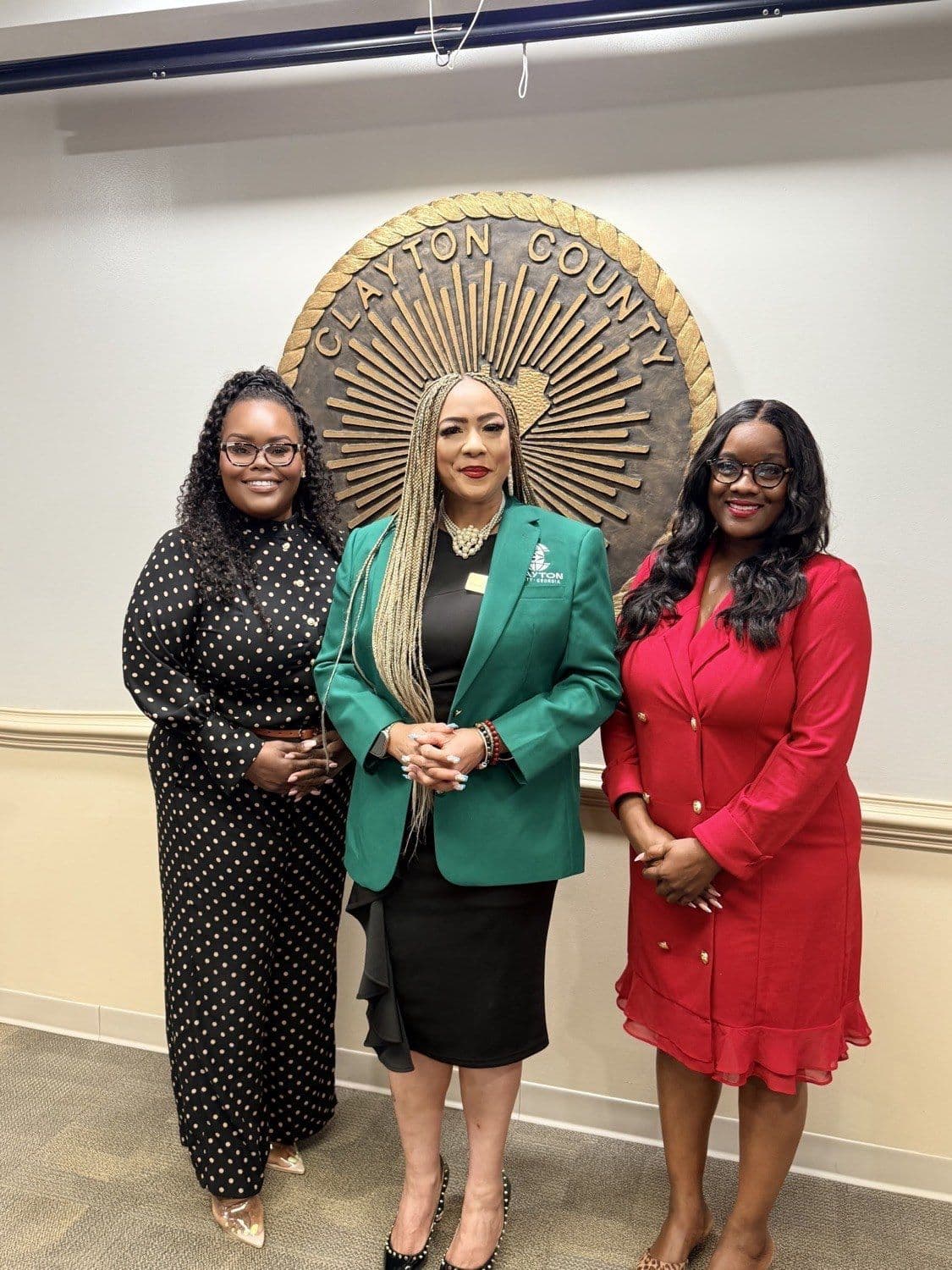 Members of the Fresh Hope team with Clayton County Board of Commissioners Chairwoman Dr. Alieka Anderson Henry, standing before the Clayton County seal.