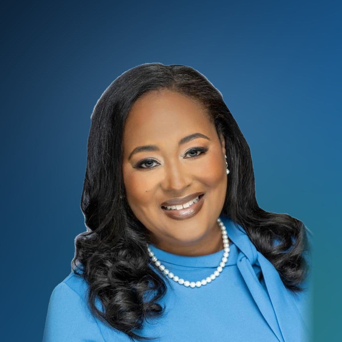 Councilwoman Tracie Arnold, smiling, in a sky blue top and pearls.